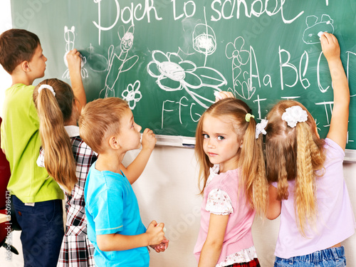 Photo: Children writing on blackboard. Children writing on blackboard.