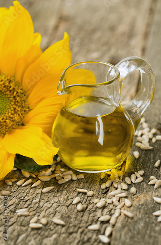 Photo: sunflower seed oil on wooden surface sunflower seed oil on wooden surface