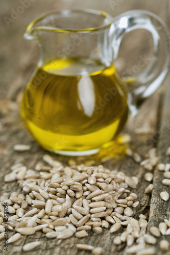 Photo: sunflower seed oil on wooden surface sunflower seed oil on wooden surface