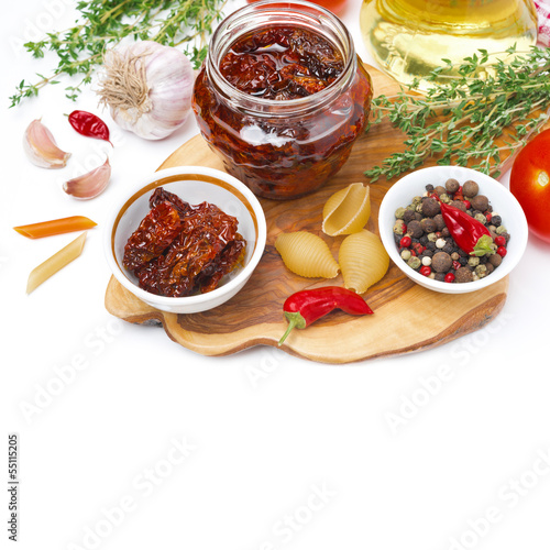 Photo: sun dried tomatoes, pasta and spices on wooden board, isolated sun dried tomatoes, pasta and spices on wooden board, isolated
