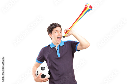 Photo: Male sport fan holding a football and horn Male sport fan holding a football and horn