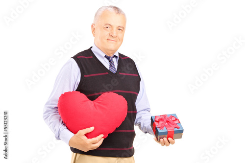 Photo: Mature gentleman holding a red heart and a gift Mature gentleman holding a red heart and a gift