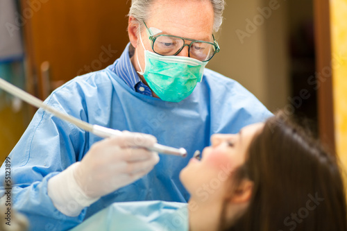Photo: Dentist doing a treatment Dentist doing a treatment