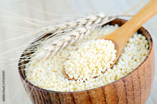 Photo: Bowl of couscous with spoon wooden Bowl of couscous with spoon wooden
