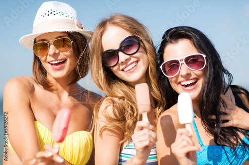 Photo: girls in bikinis with ice cream on the beach girls in bikinis with ice cream on the beach