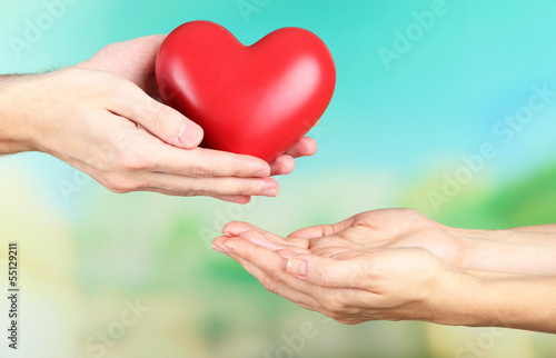 Photo: Heart in hands on nature background Heart in hands on nature background
