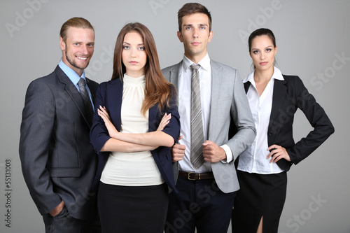 Photo: Business team standing in row on grey background Business team standing in row on grey background