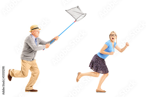 Photo: Scared female trying to runaway from man with net Scared female trying to runaway from man with net