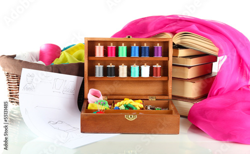 Photo: Sewing kit in wooden box with books and cloth isolated on white Sewing kit in wooden box with books and cloth isolated on white