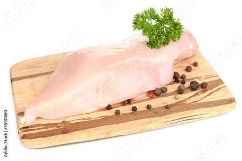 Photo: Raw chicken fillets on wooden board, isolated on white Raw chicken fillets on wooden board, isolated on white
