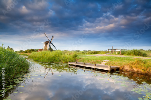 Photo: windmill on riverside with reflected sky windmill on riverside with reflected sky