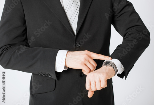 Photo: man looking at wristwatch man looking at wristwatch