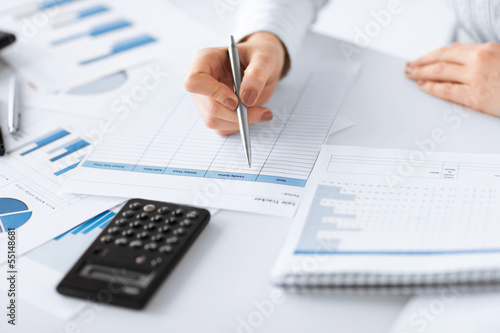Photo: woman hand with calculator and papers woman hand with calculator and papers