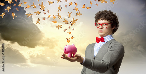 Photo: Young businessman holding moneybox Young businessman holding moneybox