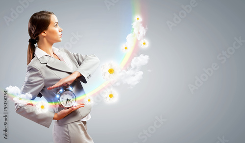 Photo: Businesswoman holding alarmclock Businesswoman holding alarmclock