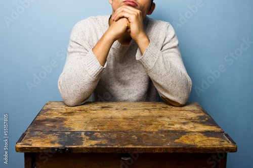 Photo: Man sitting at desk deep in thought Man sitting at desk deep in thought