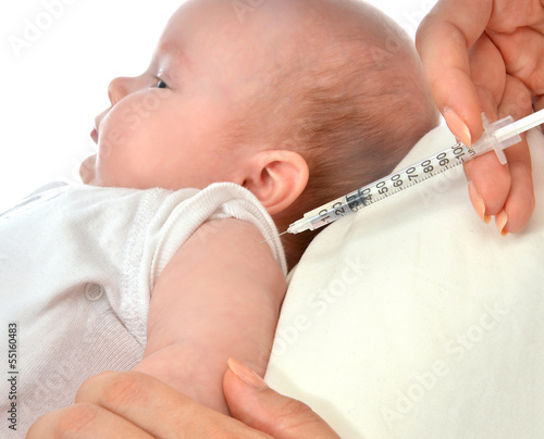Photo: Doctors hand with syringe vaccinating child baby flu Doctors hand with syringe vaccinating child baby flu