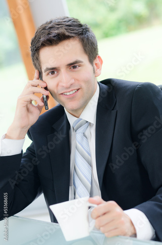 Photo: freundlicher geschäftsmann beim telefonat freundlicher geschäftsmann beim telefonat