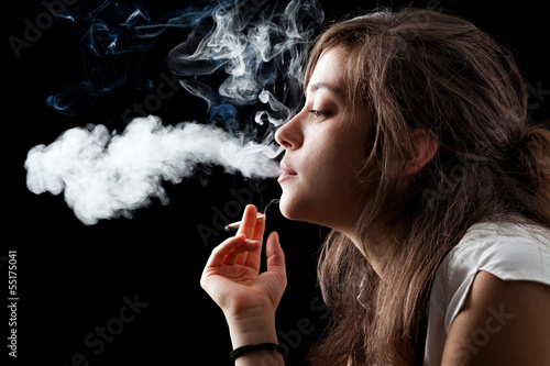 Photo: Woman Smoking a Cigarette on Black Background Woman Smoking a Cigarette on Black Background