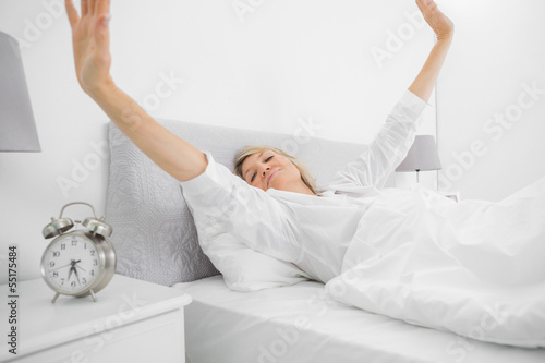 Photo: Well rested woman waking up and stetching Well rested woman waking up and stetching