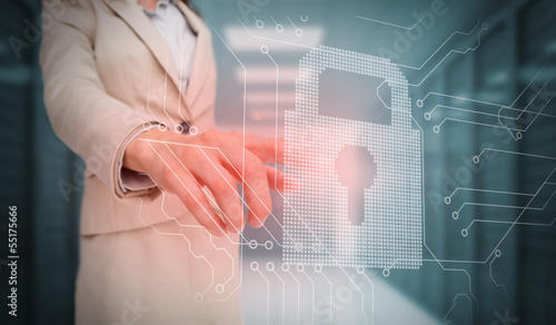 Photo: Businesswoman touching lock and circuit board graphic Businesswoman touching lock and circuit board graphic
