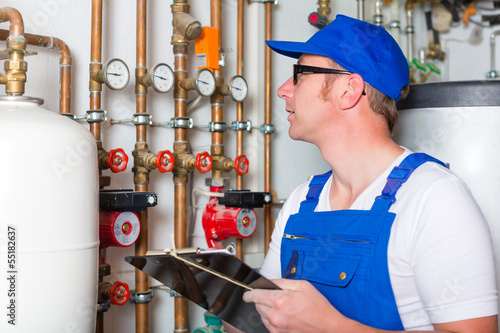 Photo: Handwerker kontrolliert die Heizungsanlage Handwerker kontrolliert die Heizungsanlage