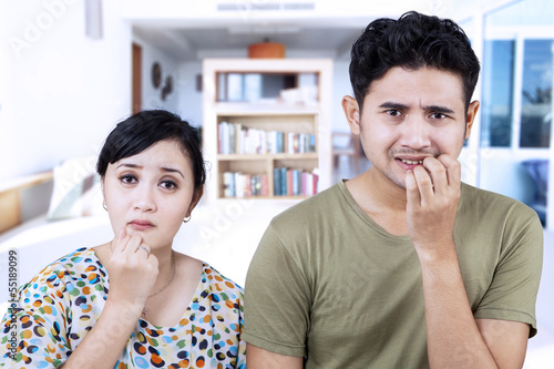 Photo: Afraid couple biting nails at home Afraid couple biting nails at home