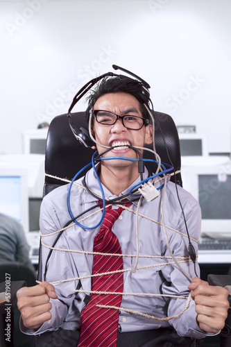 Photo: Stress businessman tied in rope at office Stress businessman tied in rope at office