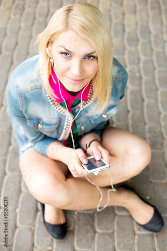 Photo: Young blond girl listening music Young blond girl listening music