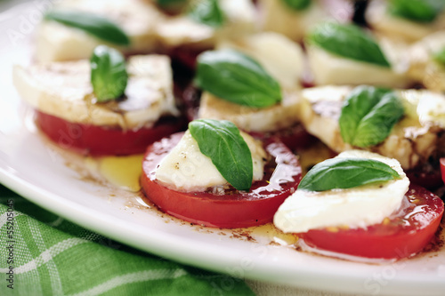Photo: Fresh caprese salad with delicious tomatos + mozzarella and bas Fresh caprese salad with delicious tomatos + mozzarella and bas