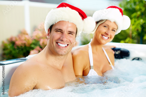 Photo: Happy Christmas santa couple in jacuzzi. Happy Christmas santa couple in jacuzzi.