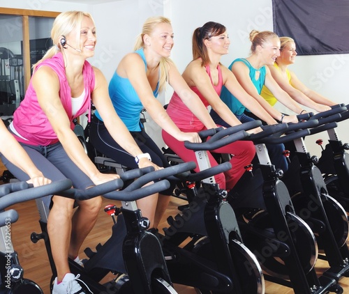 Photo: Beautiful women doing exercise in a spinning class at gym Beautiful women doing exercise in a spinning class at gym