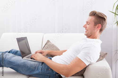 Photo: Young Man Using Laptop Young Man Using Laptop