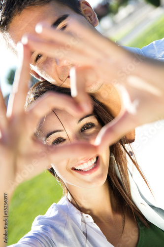 Photo: Young couple having fun in a park Young couple having fun in a park