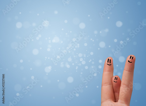 Photo: Happy finger smileys with empty blue bokeh background Happy finger smileys with empty blue bokeh background