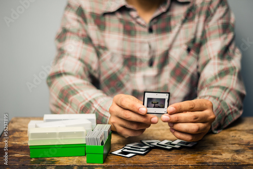 Photo: Man looking at his old slides Man looking at his old slides