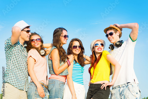 Photo: group of young people wearing sunglasses and hat group of young people wearing sunglasses and hat