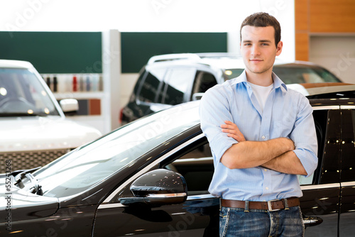 Photo: man standing near a car man standing near a car