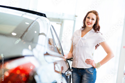 Photo: young woman standing near a car young woman standing near a car