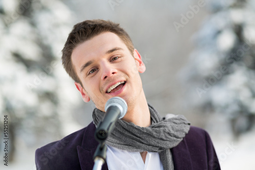 Photo: The singer in suit and scarf sing outdoors in winter The singer in suit and scarf sing outdoors in winter