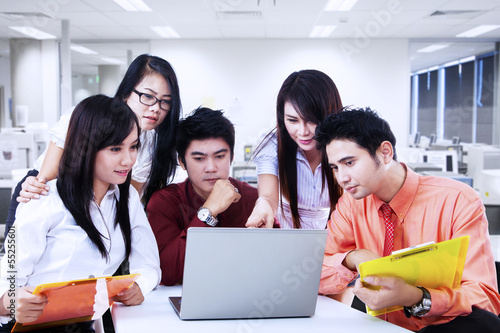 Photo: Business team discussion on laptop at office Business team discussion on laptop at office