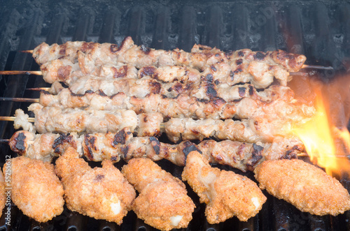 Photo: Porc skewers and chicken wings on grill Porc skewers and chicken wings on grill