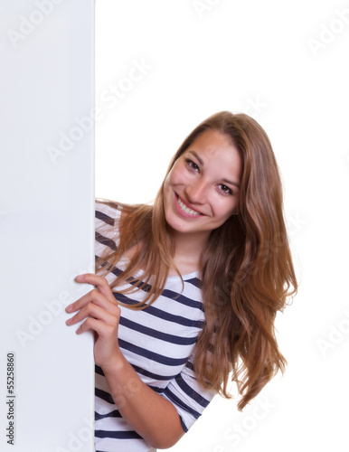 Photo: Laughing young woman with blonde hair behind a signboard Laughing young woman with blonde hair behind a signboard