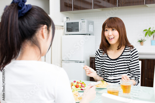 Photo: beautiful asian women eating in the kitchen beautiful asian women eating in the kitchen