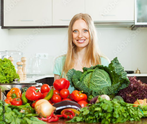 Photo: positive woman with pile of raw vegetables positive woman with pile of raw vegetables