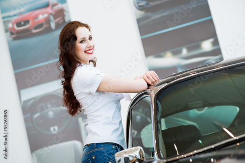 Photo: young woman standing near a car young woman standing near a car