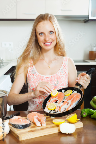 Photo: woman cooking salmon with lemon woman cooking salmon with lemon