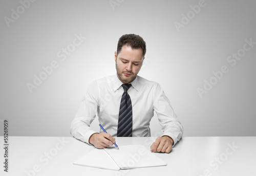 Photo: young man writing on paper young man writing on paper