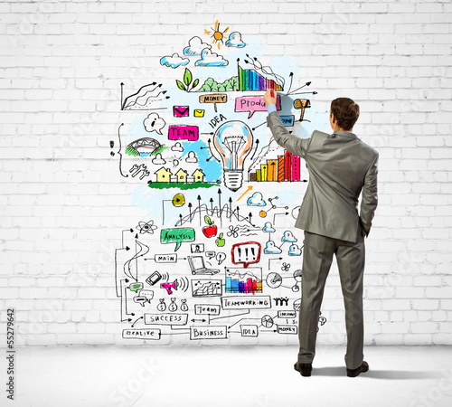 Photo: Businessman drawing sketches on wall Businessman drawing sketches on wall