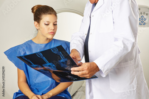 Photo: Patientin schaut mit Arzt auf Röntgenbilder Patientin schaut mit Arzt auf Röntgenbilder